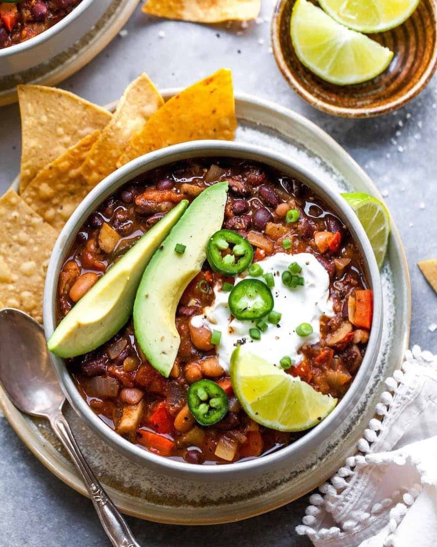 serving-of-chili a serving of turkey and bean chili with tortilla chips and lime on the side