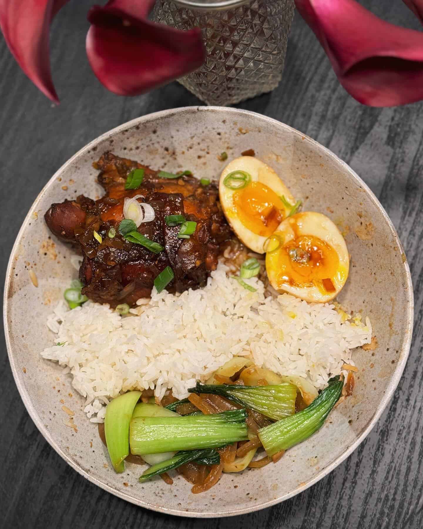 serving-of-filipino-chicken-adobo serving of chicken adobo with bok choy and boiled eggs on the side