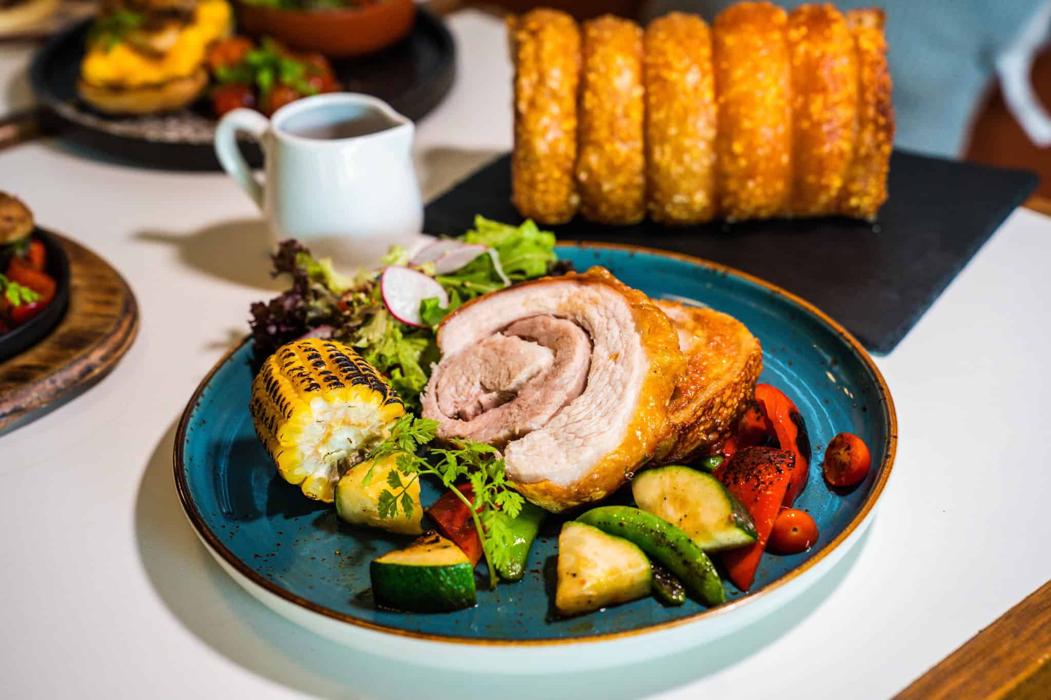 serving of crispy pork belly with vegetables on the side